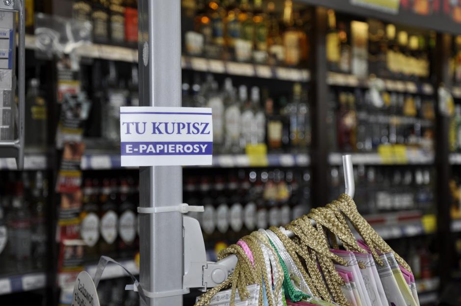 Nowoczesne, kompaktowe urządzenie typu pod system do e-papierosów, z buteleczką płynu do napełniania, symbolizujące ekonomiczną alternatywę dla palenia.